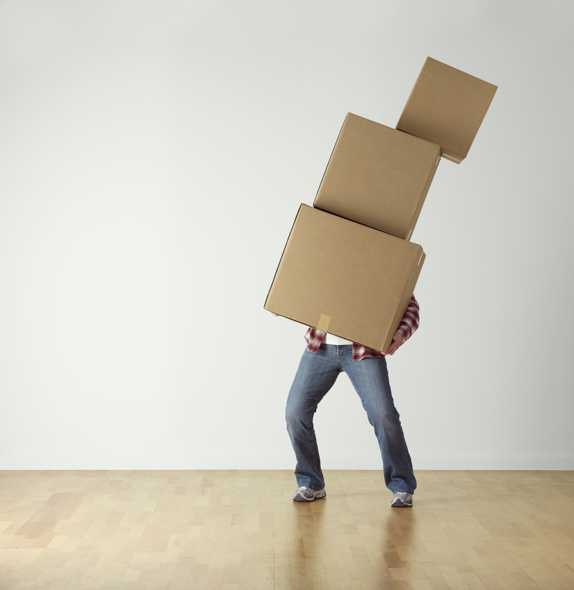 Photo of person carrying large stack of boxes.